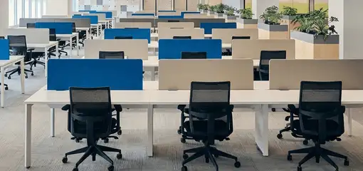 Modern open-plan office space featuring clean workstations, ergonomic chairs, and sanitized carpets provided by professional office cleaning services in Yonkers, NY.